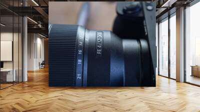 Closeup of a modern DSLR camera under the lights with a blurry background Wall mural