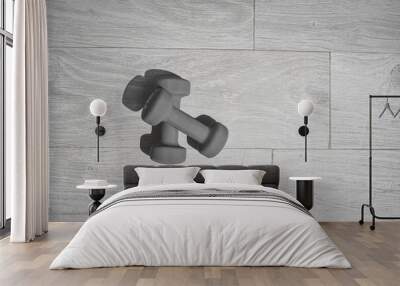 Grayscale shot of a pair of black dumbbells on wooden background Wall mural