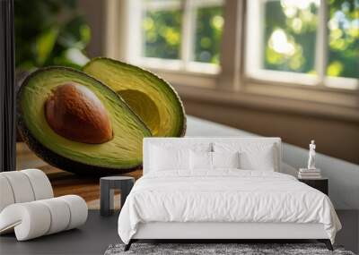 Close-up of halved Hass avocado with seed on wooden cutting board Wall mural