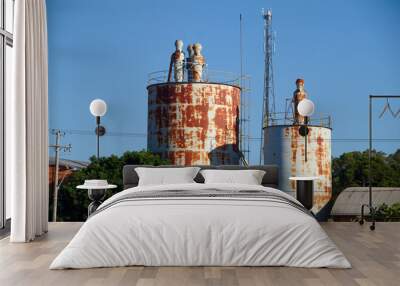 Beautiful shot of the rusty metallic water tank in a village Wall mural