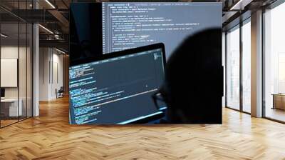 Vertical shot of male writing coding on three screens. Software programmer and web developer Wall mural