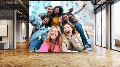 A group of happy people is sharing a fun moment. Young friends take a selfie picture during a leisure event. The team is traveling together. Smiling community portrait looking at camera Wall mural