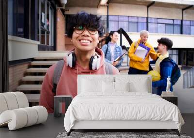 Close up shot of cheerful happy Asian teenage guy looking at camera smiling. Funny portrait of a young male student boy at campus university. Man laughing at high school. Wall mural