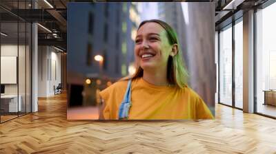 Copy space portrait of a young blonde Caucasian student girl positive expression standing in front of the city work area building. Smiling and cheerful gesture looking up around. Inspirational shot Wall mural