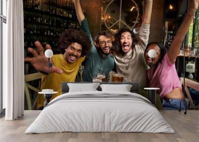 Group of four cheerful young friends taking selfie portrait inside the bar at happy hour. Happy people having fun looking at the camera smiling. Concept of community, youth lifestyle and friendship. Wall mural