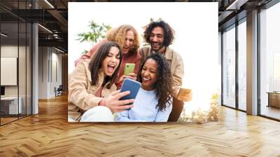 Happy friends watching screen mobile phone with a surprised face and smiling. Young adult people using smartphone and having fun. Wall mural