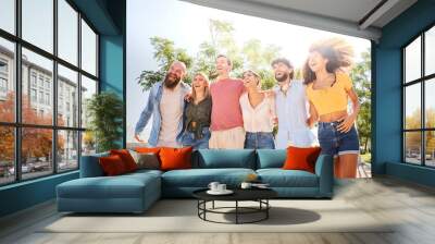 Happy group of smiling friends enjoying the summer holidays together and having fun together outdoors Wall mural