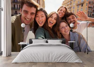 Mobile selfie of group young multi-ethnic beautiful friends having fun together outdoors. Excited people looking at happy camera enjoying sightseeing in city on sunny day. Generation z and vacations. Wall mural