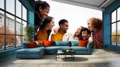 Multi-ethnic group of friends hugging and having fun. Isolated young smiling people laughing togethers enjoy the community. Wall mural