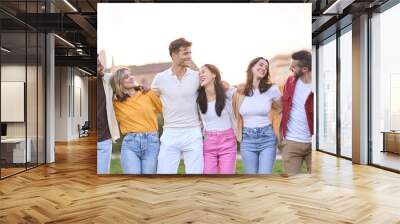 Multirracial group of cheerful young friends together at the park outdoors. This gathering cheerful people in vacation having fun and laughing. Social gathering of diverse students Wall mural