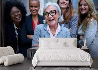 Portrait of smiling entrepreneurs in suits from an empowered happy women business in city. A group of five joyful female of diverse races and ages looking laughing at camera with arms crossed outdoor Wall mural