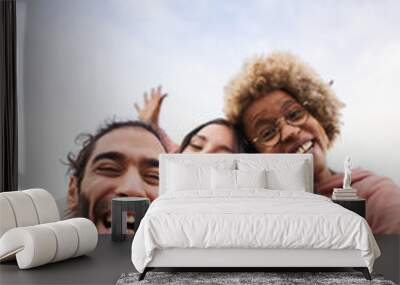 Vertical pic of Group of young people looking at the camera outdoors. Happy smiling friends hugging. Concept of community and youth lifestyle Wall mural