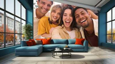 Vertical selfie of a Group of happy multiracial friends having fun outdoors at the park. Diverse cheerful joyful young people looking at the camera and smiling all together. They are hug and laugh Wall mural