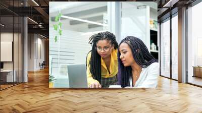 Vertical shot two young businesswoman using touchpad at meeting. Wall mural