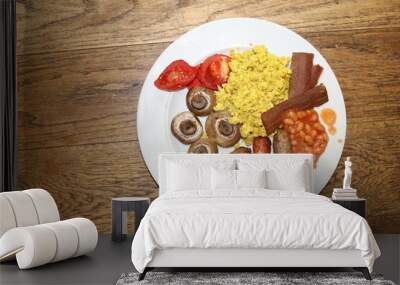 Close up vegan breakfast dairy meat free delicious full English vegetarian tofu spice scramble mock egg, plant bacon sausages tomatoes mushroom, beans and bread roll served white plate wood background Wall mural