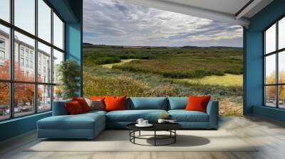 Landscape view of beautiful nature reserve for bird watching wildlife lakes in marsh land by ocean in Cley Next the Sea Norfolk East Anglia uk reeds grass by water lake on Summer day blue cloud skies Wall mural