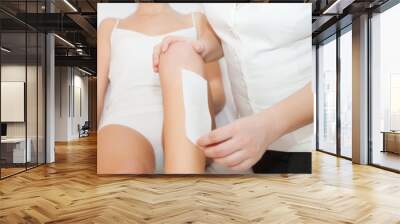 Young women waxing legs Wall mural