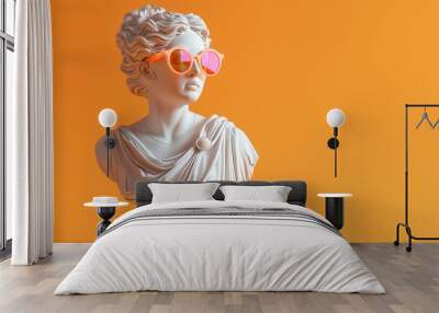 A white marble statue of ancient greek goddess wearing modern pink sunglasses on a orange background Wall mural