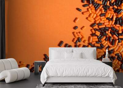 Orange and black sprinkles design on orange background, halloween theme Wall mural