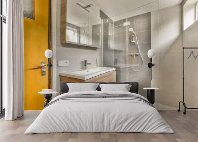 a bathroom with a yellow door and white tiles on the wall behind it is a wooden vanity, sink and mirror Wall mural