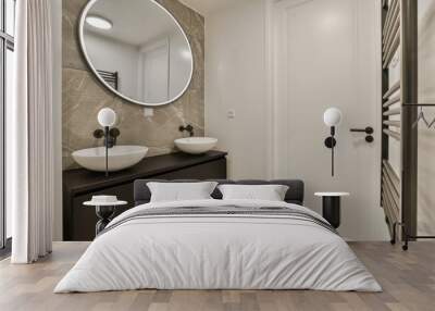 a bathroom with two sinks and a large round mirror on the wall in front of the sink is dark wood Wall mural