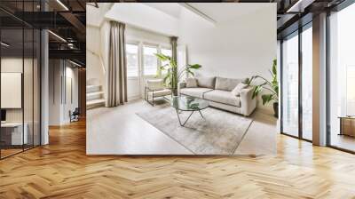 a living room with white walls and hardwood flooring, including a gray couch in the center of the room is a glass coffee Wall mural