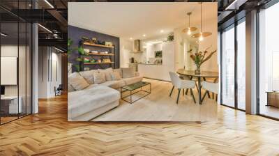 a living room with white walls and wood flooring, there is a small dining table in front of the couc Wall mural