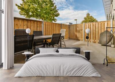 a patio with chairs, table and grill in the back yard on a sunny day there is a blue sky Wall mural