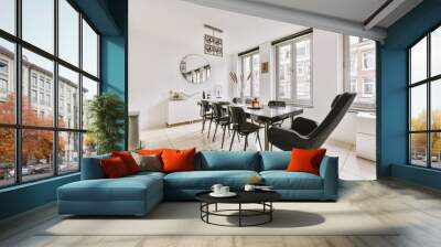 Black stylish chairs and a large table in a bright room with large windows Wall mural