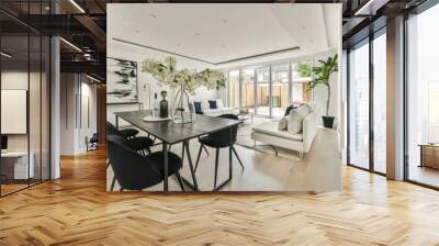 Contemporary minimalist style interior design of light studio apartment with wooden table and chairs in dining zone between open kitchen and living room with white walls and parquet floor Wall mural