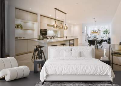 White cabinets with wooden counter of modern kitchen and dining table set in living room of apartment Wall mural