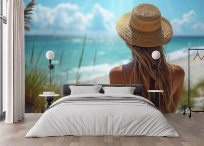 young woman with straw hat on the beach looking at the ocean Wall mural