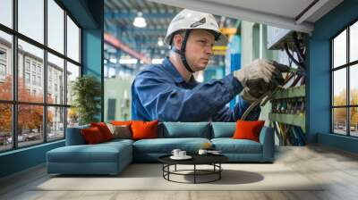 electrican working in a factory, worker with helmet, electrical worker in action Wall mural