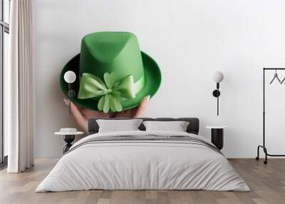 Hands holding green hat four leaf clover bow ribbon on white background. St.patrick's day, Mock up template product presentation. Copy text space. Wall mural