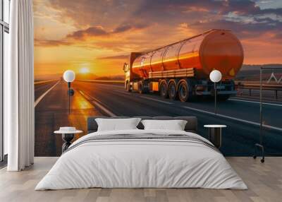 A chemical tanker truck travels on a highway during a vibrant sunset, illustrating logistics and transportation of hazardous materials in a scenic environment. Wall mural