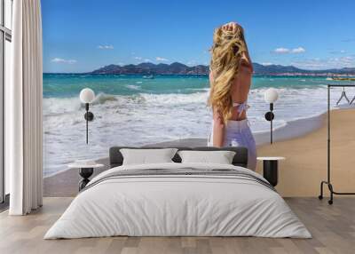 Girl at the beach in Cannes, France. Beautiful Seaside background. Back view Wall mural