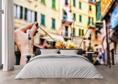 Seafood in Cinque terre Italy. holding fresh delicious fried fish specialities at street background Wall mural