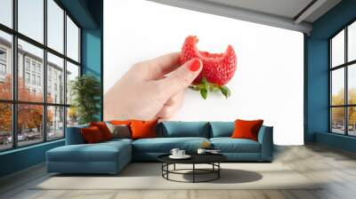 Strawberry bitten in woman's hand. Wall mural