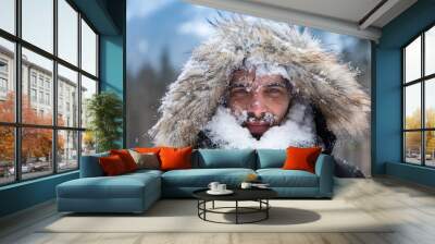 Man's face covered with snow against the backdrop of winter mountains Wall mural