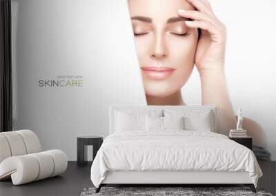 Beauty portrait of a young woman with green leaves. Spa, skin care and cosmetology concept. Wall mural