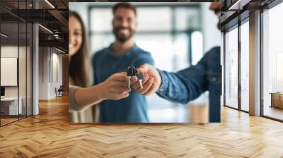 Man handing over keys of his new house to smiling couple indoors Wall mural