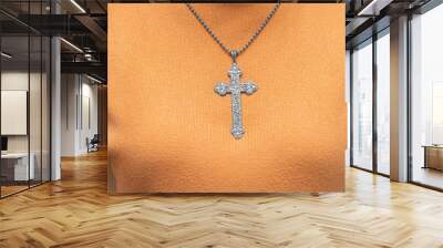 Silver vintage crucifix pendant or cross sign and chain necklace and close-up orange sweater. Easter festival. Faith. Christian. Jesus Wall mural