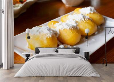 Vietnamese fried banana dough topping with Powdered sugar or icing sugar. serving on white square plate Wall mural