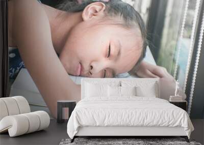 Beautiful asian child read books on the table and fall asleep. Wall mural