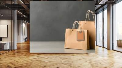 Two brown paper shopping bags on a grey background with copy space  Concept of retail consumerism e commerce and modern shopping experience Wall mural