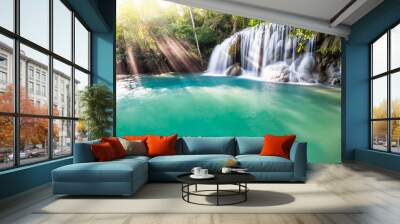 Waterfall and blue emerald water color in Erawan national park with sun light and light ray sunflare, Beautiful nature rock waterfall steps in tropical rainforest at Kanchanaburi province, Thailand Wall mural