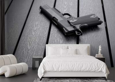 Classic airsoft gun placed on a dark wooden board. Wall mural