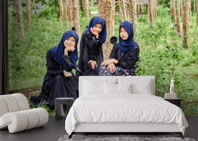 Group of asian muslim girls sitting on rubber forest field Wall mural