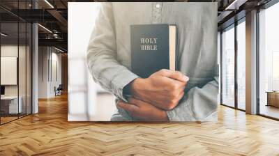 man holding and reading the holy christian bible. Wall mural