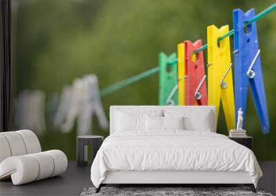 Plastic Colourful clothes pegs on a washing line Wall mural